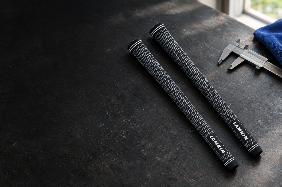 Two Lamkin golf grips beside a calliper on a workshop bench